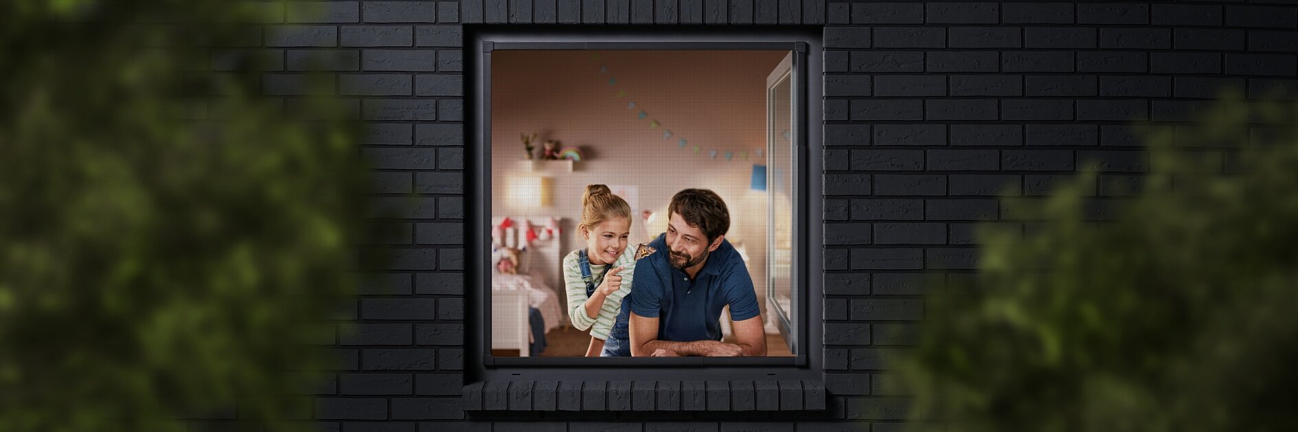 A man and a child are seen through a window, looking into a room decorated with colorful bunting. The building has dark brick walls, and the view is partially framed by blurred greenery. The man is wearing a blue shirt, and the child is sitting beside him. (This text has been generated by AI)