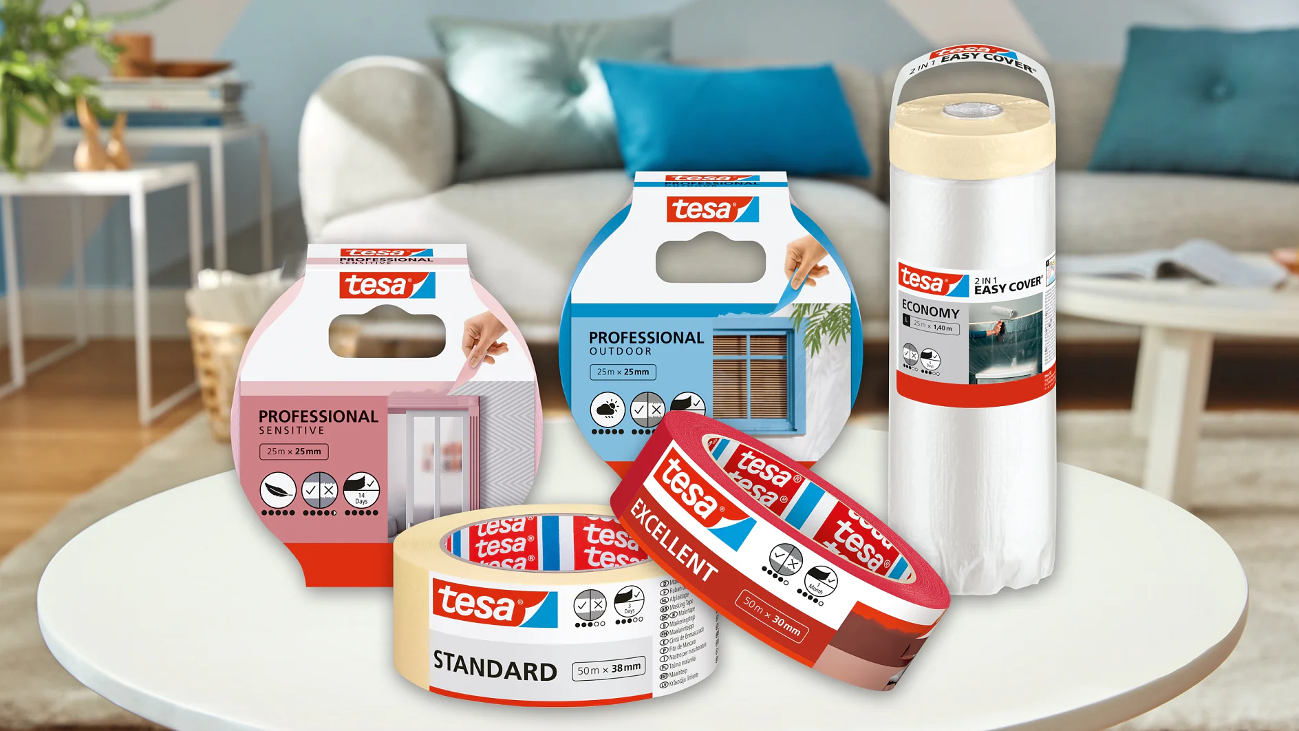Uma variedade de produtos de fita tesa são exibidos em uma mesa branca redonda em um ambiente de sala de estar. As fitas tesa incluem opções para uso profissional, ao ar livre, superfícies sensíveis e aplicações padrão. Um sofá e uma planta são visíveis no fundo desfocado. (This text has been generated by AI)