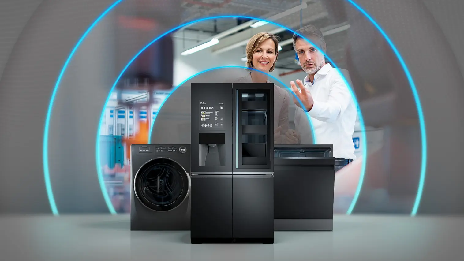 Two people gesturing towards sleek black kitchen appliances, such as a washing machine, refrigerator, and dishwasher. The image showcases a modern setting with blue light arcs surrounding the appliances.