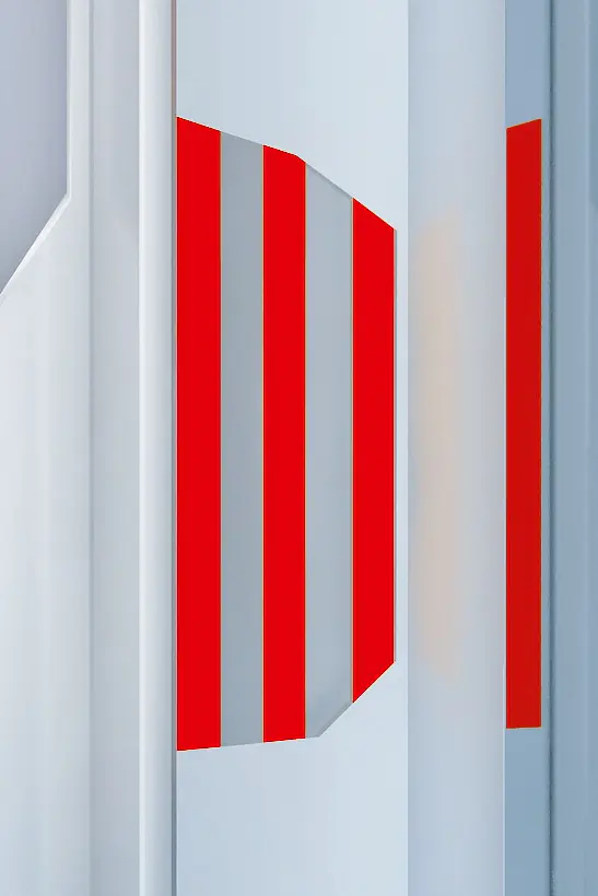 Abstract image featuring red and white geometric patterns on a flat surface, created using tesa tape. The design includes vertical red tesa tape stripes and angled shapes against a white and gray background, creating a modern and dynamic appearance. (Acest text a fost generat de inteligența artificială)