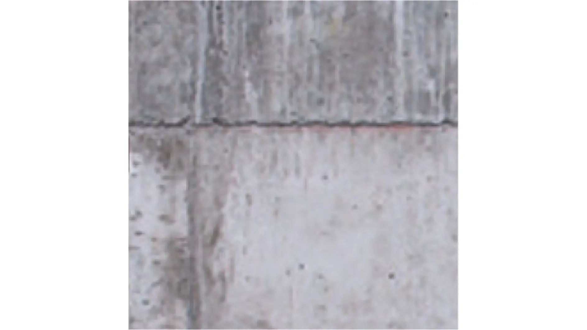 Prim plan al unei secțiuni de perete din beton gri cu rosturi orizontale și verticale vizibile. Suprafața are o textură aspră cu pete mai întunecate împrăștiate. Imaginea arată două panouri de beton aliniate, cu un ușor spațiu între ele, fixate cu bandă tesa. (Acest text a fost generat de inteligența artificială)