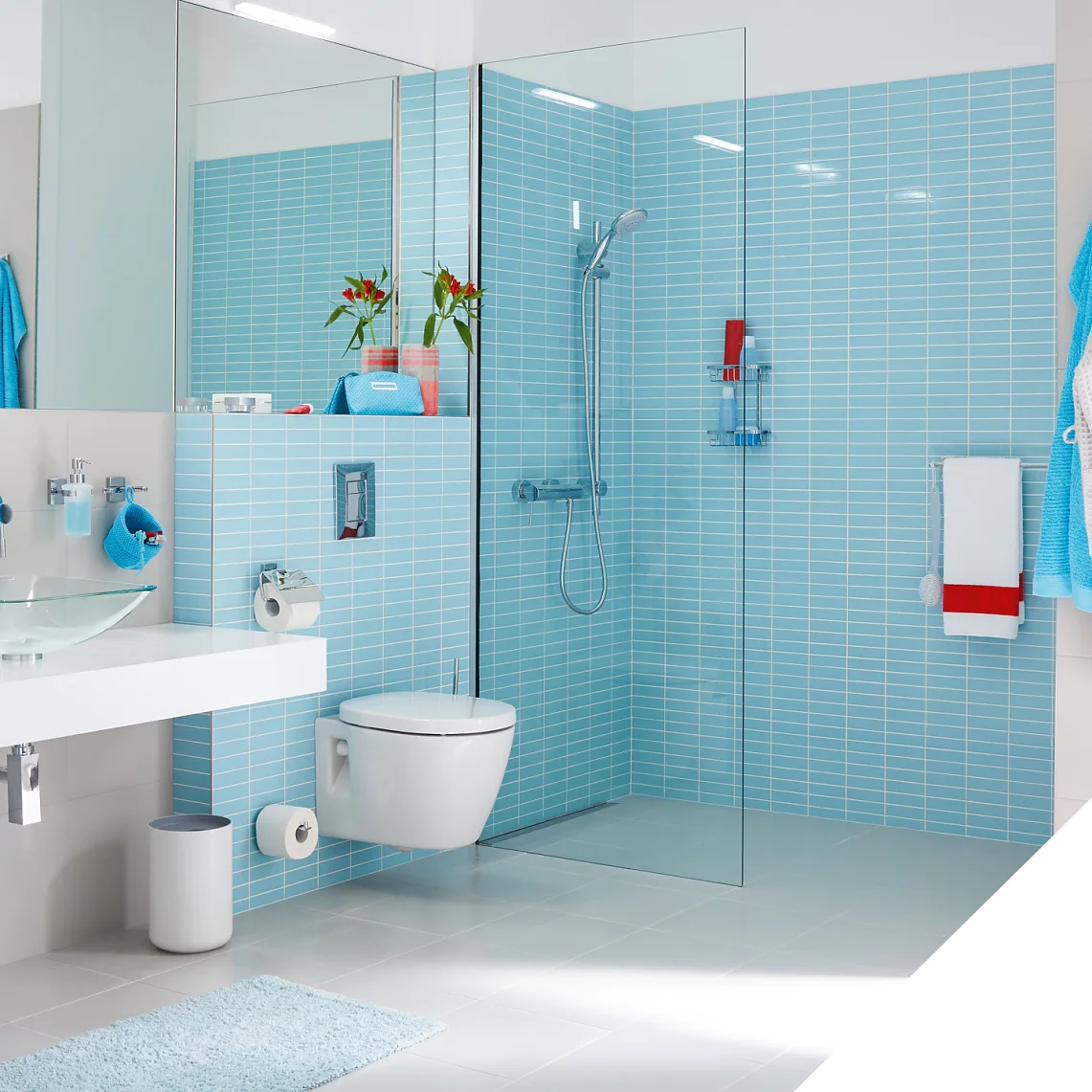 Baie modernă cu gresie albastru deschis și corpuri albe. Are un duș cu cabină de sticlă, toaletă montată pe perete și un blat cu o chiuvetă cu vas de sticlă. Prosoapele luminoase adaugă culoare. Un cârlig de perete atașat cu bandă tesa este prezentat în interior. (This text has been generated by AI)