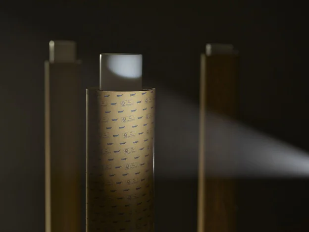 three vertical rectangular objects with perforated surfaces in a dark setting, one emitting a focused beam of light to the right (This text has been generated by AI)