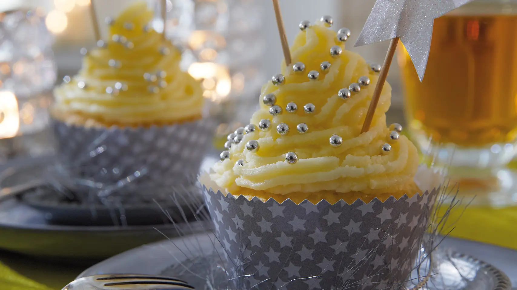Die Cupcakes tragen ein festlich gemustertes Kleid. Passende Accessoires dazu: Deko-Sticks mit glitzernden Sternen.