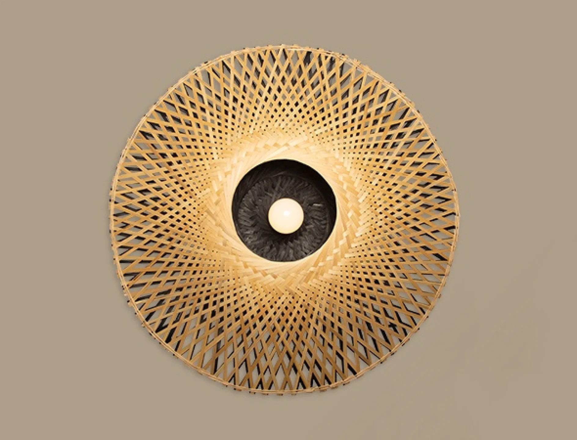 En taklampa med ett vävt, cirkulärt mönster och en central glödlampa. Designen liknar en solstrålning, med naturfärgade material mot en neutral bakgrund. I den här installationen kan tesa-tejp användas för att säkert hänga upp armaturen, vilket ger styrka utan att ge avkall på stilen. (This text has been generated by AI)