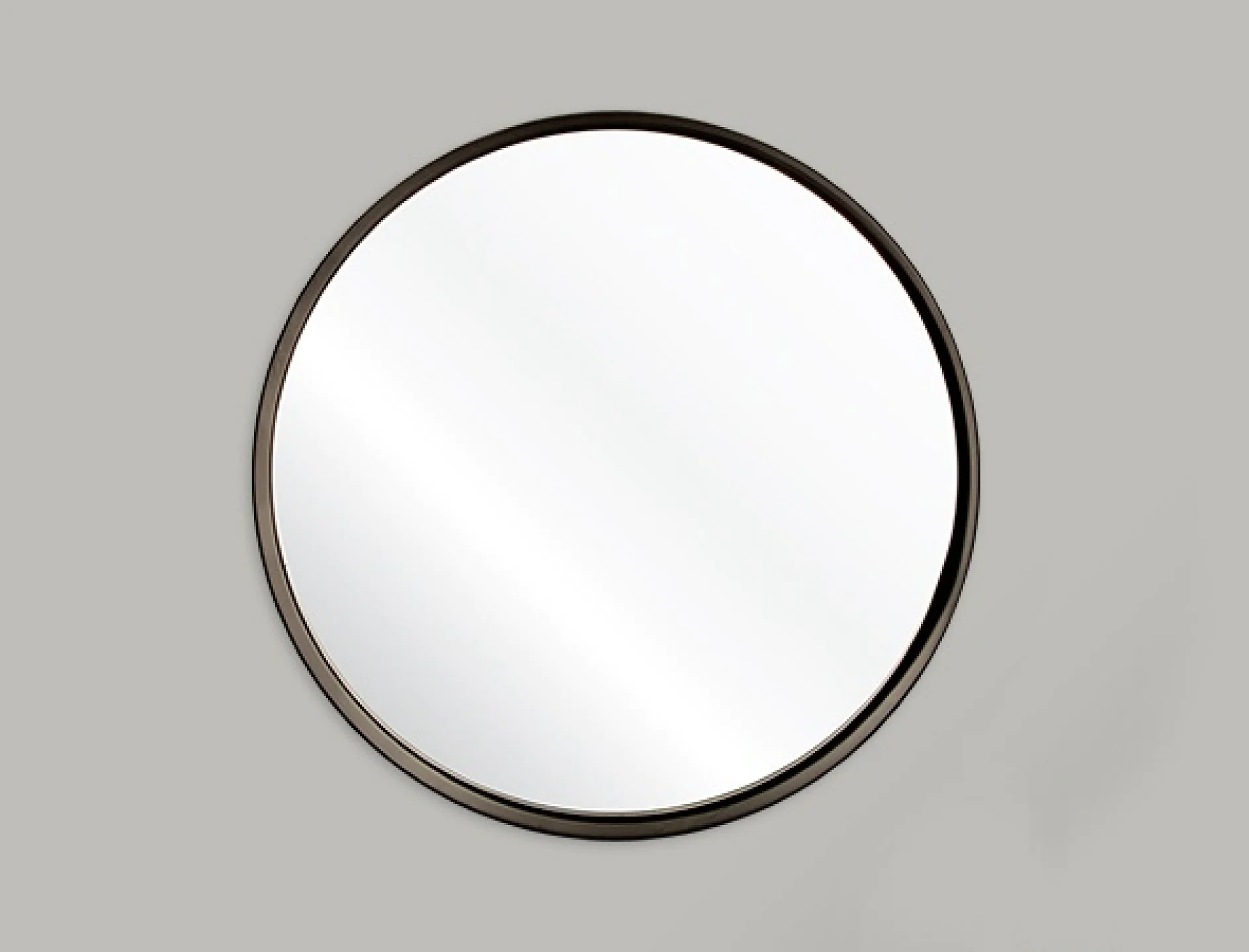 Rund spegel med svart ram monterad på en vanlig ljusgrå vägg, med tesa-tejp. Spegelns yta reflekterar ljus och skapar en subtil vit gradient över den. (This text has been generated by AI)