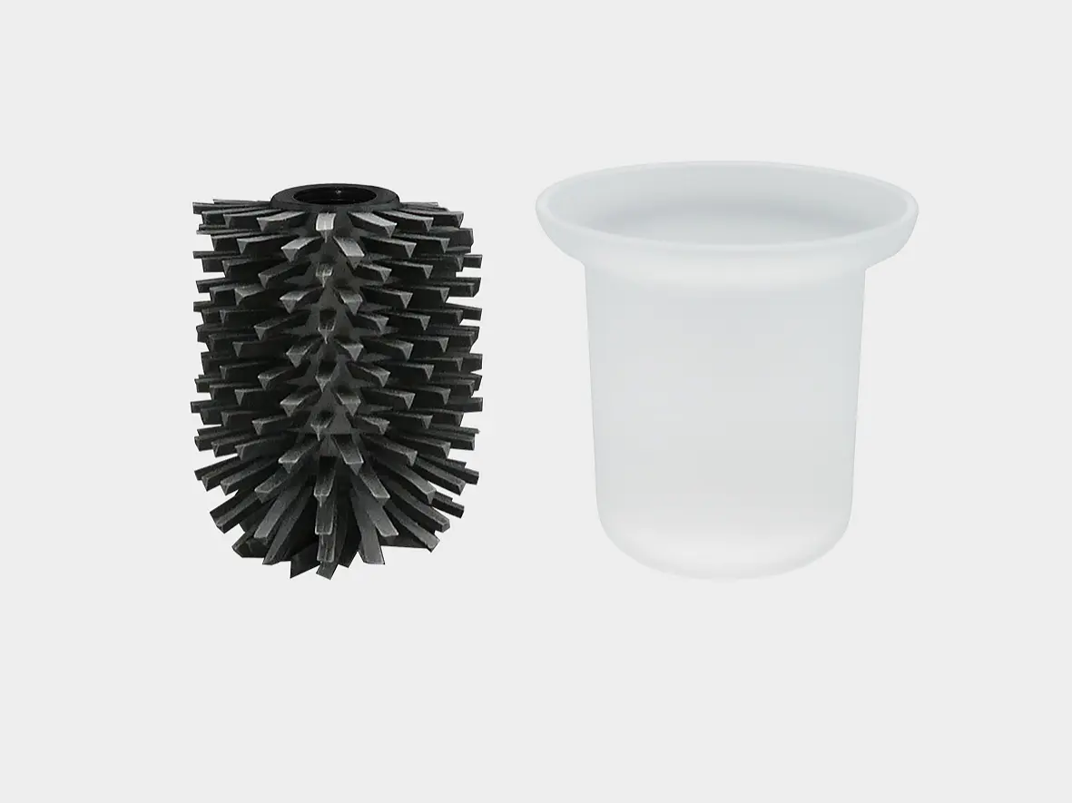 The image shows a black toilet brush head with spiky bristles and a white, round, smooth-edged holder placed next to it against a plain, light gray background. (This text has been generated by AI)
