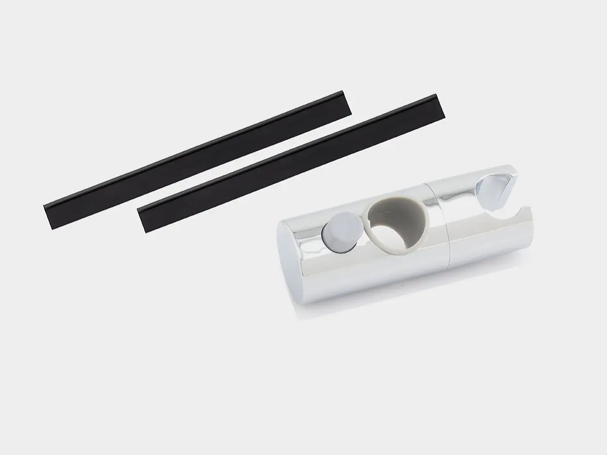 A cylindrical silver object with a notch on one end and a circular cutout on the side is placed next to two thin, black rectangular pieces of tesa tape against a white background. (This text has been generated by AI)