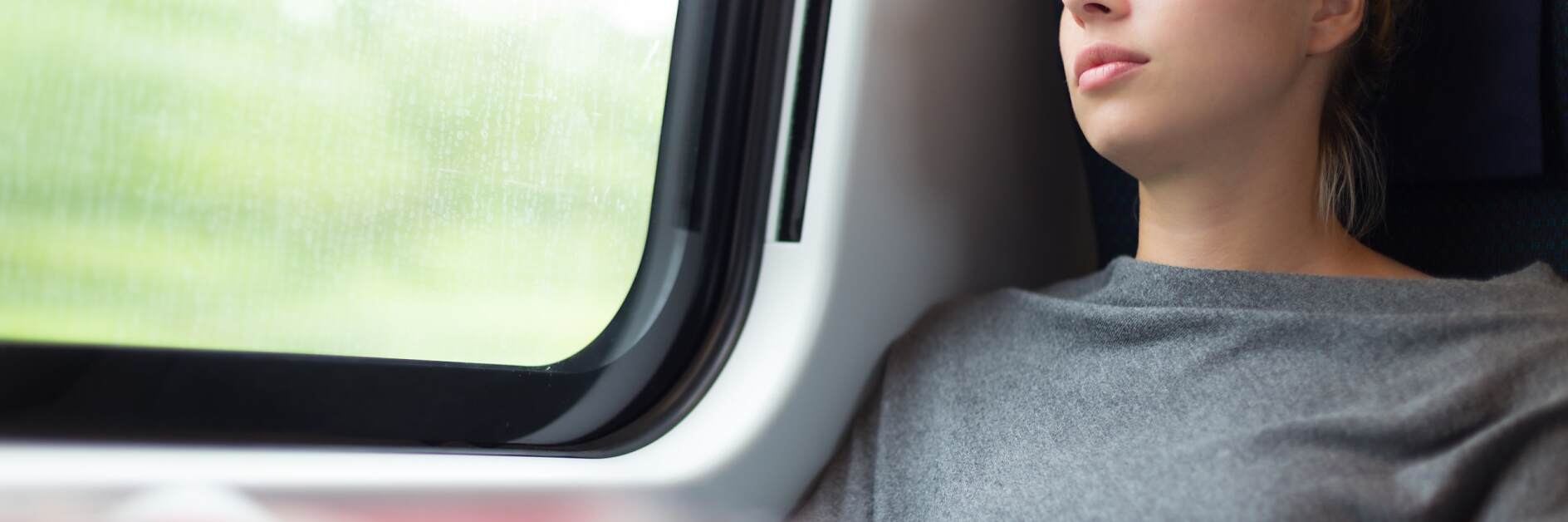 ผู้หญิงงีบหลับขณะเดินทางบนรถไฟ