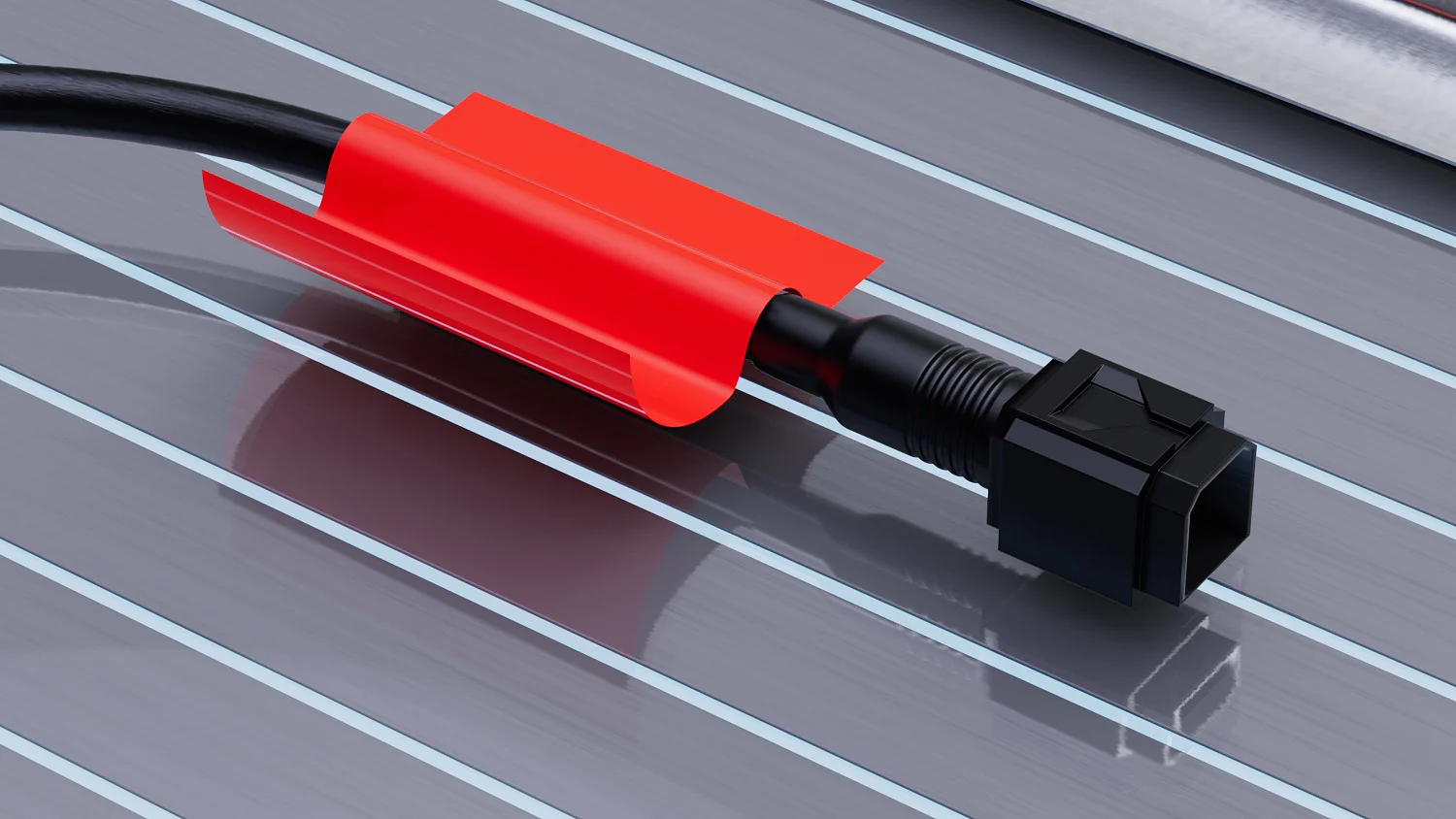 A black cable with a connector is wrapped in a red protective sheath, lying on a metallic, grooved surface. The grooves in the surface run parallel to the cable. The background is a light sky blue. (This text has been generated by AI)