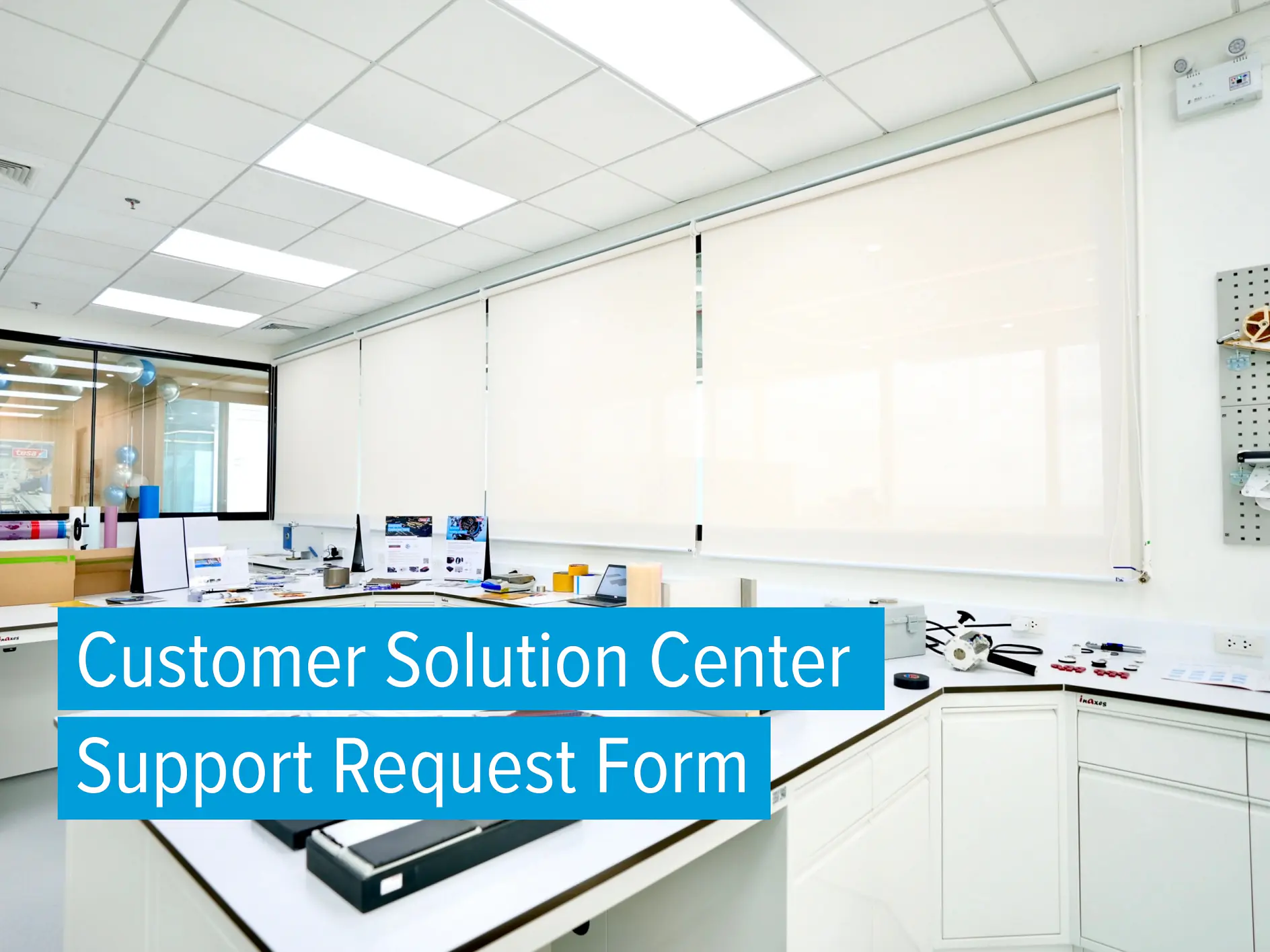 พื้นที่สำนักงานที่สว่างและทันสมัย พร้อมด้วยโต๊ะทำงาน อุปกรณ์สำนักงาน และคอมพิวเตอร์ บนหน้าจอมีข้อความว่า “แบบฟอร์มขอความช่วยเหลือจากศูนย์บริการลูกค้า” ม่านสีขาวปิดหน้าต่างขนาดใหญ่ ห้องดูสะอาดและเป็นระเบียบ โดยมีอุปกรณ์สำนักงาน เช่น เทป tesa วางอยู่บนโต๊ะทำงาน. (This text has been generated by AI)