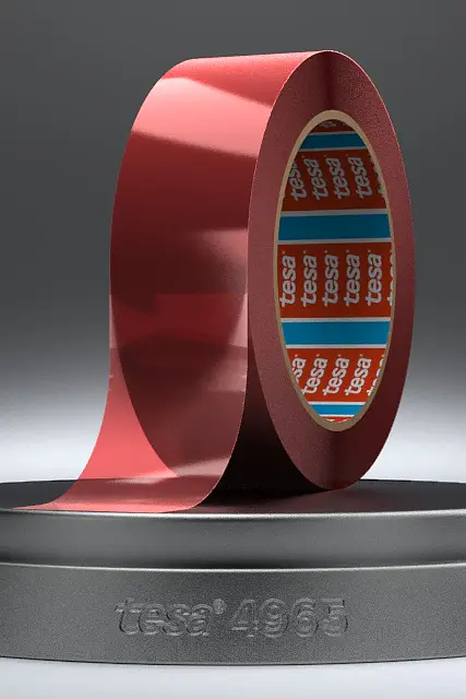 A roll of shiny red tesa tape is displayed upright on a round, dark grey stand with 1968 engraved on it. The inner core of the tesa tape has a blue design with red and white text. The background is a gradient of grey. (This text has been generated by AI)