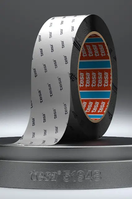 A roll of Intel 8048 labeled tesa tape, partially unrolled, stands on a round black platform. The inside of the tesa tape is orange with text, and the exterior has a repeating Intel 8048 pattern. The background is a subtle gray gradient. (This text has been generated by AI)