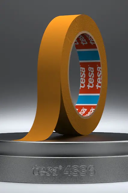 A roll of adhesive tesa tape is placed on a round pedestal. The tesa tape is brown, with visible red and blue branding inside the roll. The pedestals front has the text tesa 1936 engraved on it. The background is a neutral gray. (This text has been generated by AI)
