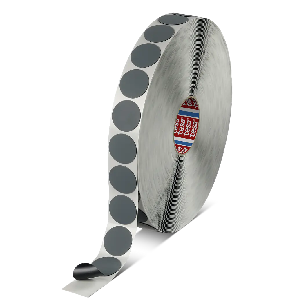 A roll of tesa tape with gray circular stickers. The roll is partially unwound, revealing the individual stickers, and is placed against a plain background. (This text has been generated by AI)