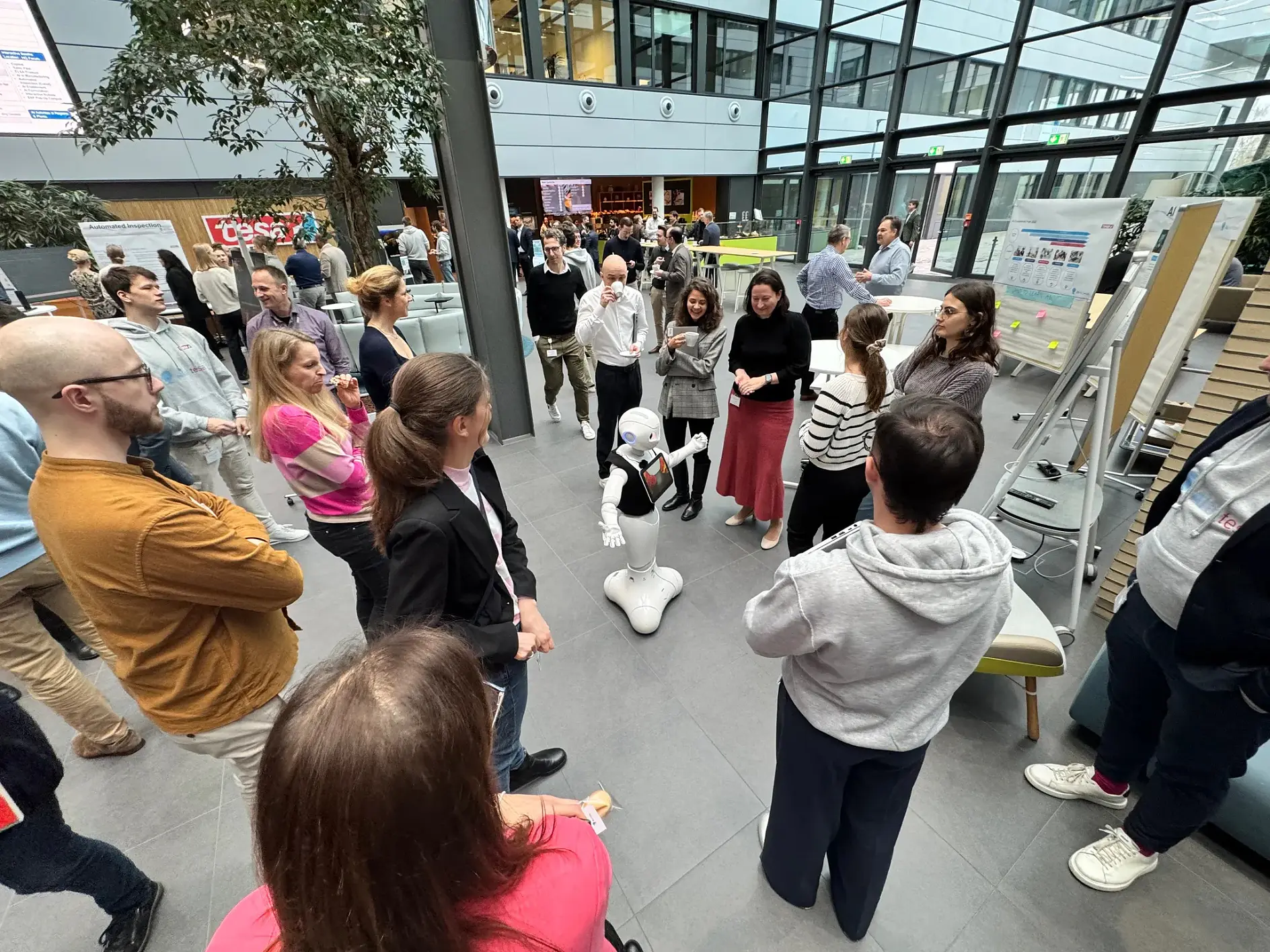 Tesa'nın ilk Global Yapay Zeka Günü'nde, çalışanlar yenilikçi yapay zeka uygulamalarını sunuyor ve dijital stratejiyi tartışıyorlar.