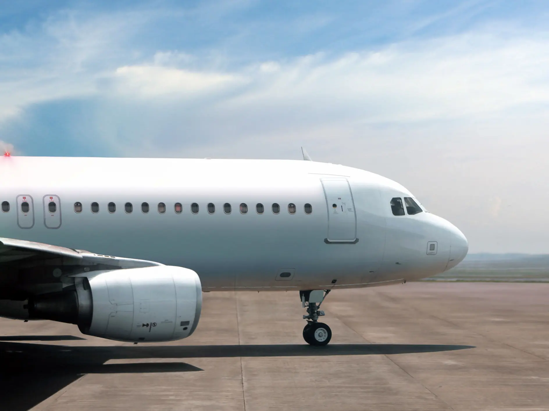 tesa airplane parked on runway under cloudy sky, showing front fuselage, cockpit, and engine on tarmac (This text has been generated by AI)